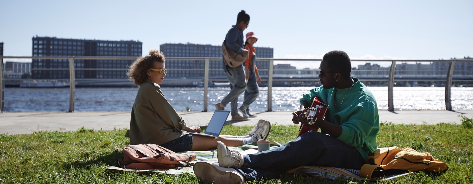 a group of people sitting on a bench in front of a body of water
