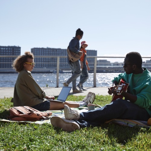 a group of people sitting on a bench in front of a body of water