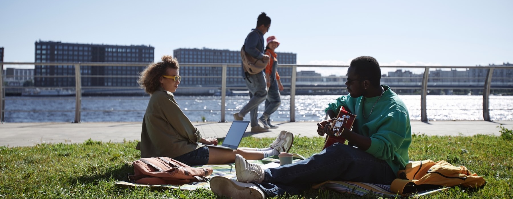 a group of people sitting on a bench in front of a body of water