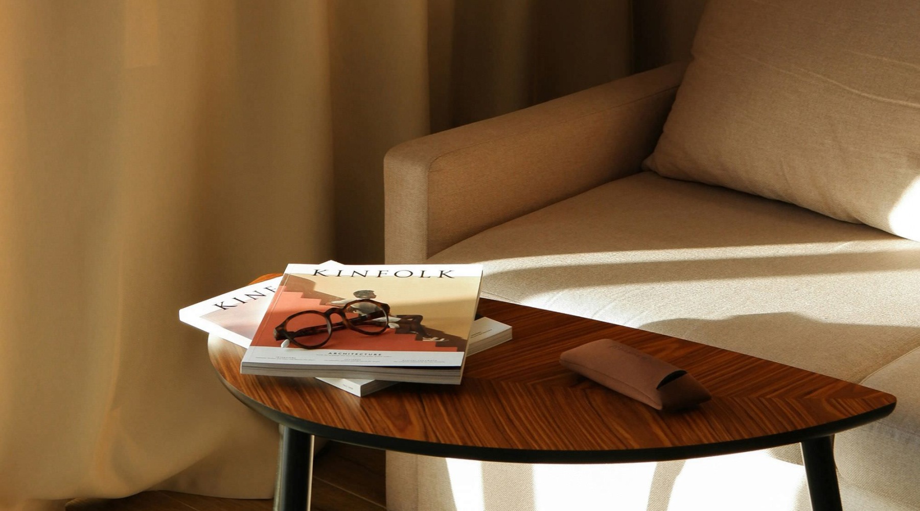 a living room with a couch, coffee table and books