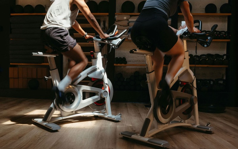 Two people working out on exercise bikes.